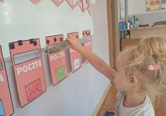 Dziewczynka z grupy Biedronki wrzuca kopertę do odpowiedniej skrzynki na listy.