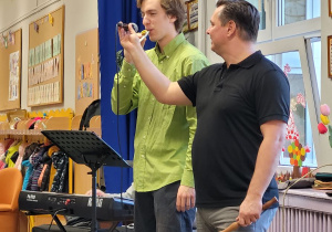 Pan Paweł wraz ze swoim gościem prezentuję flet typu „Kazoo”.