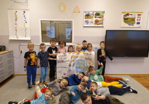 Dzieci z grupy Pszczółki pozują do zdjęcia z samodzielnie pokolorowanym plakatem Dzień Praw Dziecka.