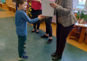 Chłopiec odbiera nagrodę wraz z nagrodą od Pani Dyrektor z zajęcie III miejsca
