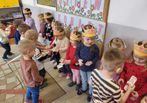 Chłopcy z grupy Stokrotki wręczają dziewczynkom samodzielnie wykonane laurki z okazji Dnia Kobiet.