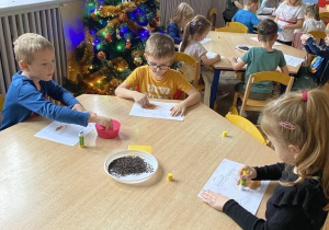 Grupa Misie wykonuje pracę plastyczną używając herbaty liściastej oraz cynamonu.