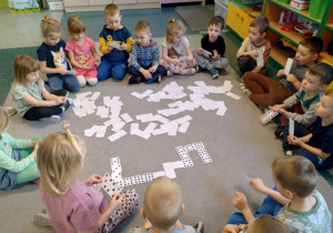 Dzieci z grupy Motyki z okazji Dnia Matematyki grają w domino matematyczne