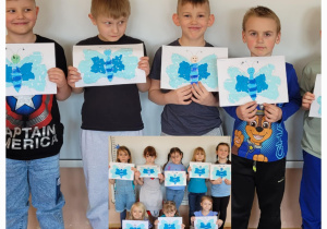 Dzieci z grupy Smerfy prezentują wykonane przez siebie symbole autyzmu niebieskie motyle.