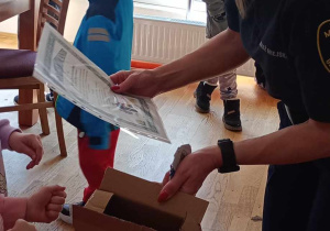 Strażniczka Miejska otrzymująca podziękowanie od dzieci za przeprowadzone zajęcia.