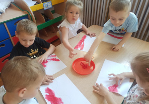 Dzieci z grupy Słoneczka wykonują flagę Polski.