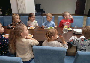 Dzieci z grupy Odkrywcy siedzą przy stole na talerzach mają pankejki.