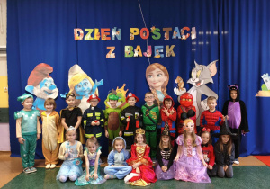 Dzieci z grupy Motylki pozują do zdjęcia grupowego w strojach bajkowych.