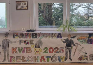 Ukończona kolorowanka wisząca pod oknami na holu przedszkolnym przedstawiająca górników oraz maszyny górnicze.