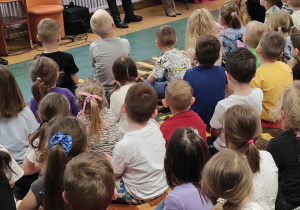 Dwie kobiety stojące naprzeciwko dzieci prezentują śpiew w języku kotów.