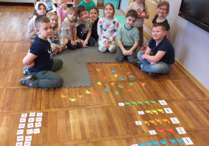 Zdjęcie przedstawia dzieci z grupy Odkrywcy wykonujące działania dodawania.