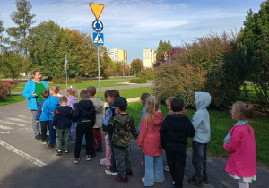 Dzieci utrwalają zasady ruchu drogowego w miasteczku ruchu drogowego.