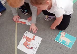 Chłopiec z dziewczynką w trakcie układania puzzli.