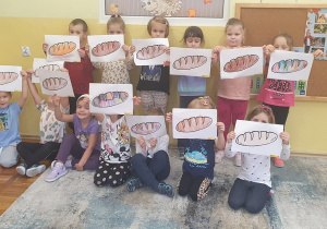 Dzieci z grupy Słoneczka przedstawiają swoje pokolorowane chlebki.