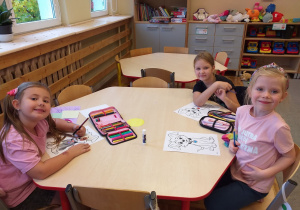 Dzieci kolorują obrazek pieska.