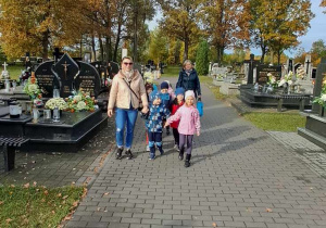 Grupa Misie wraz z Paniami spacerują po cmentarzu.