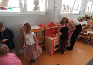 Dziewczynki bawią się z Oliwią w kąciku kucharskim.