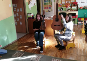 Absolwentki przedszkola opowiadają o instrumentach muzycznych.