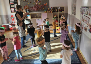 Dzieci tańczą w opaskach z bohaterami z bajek.