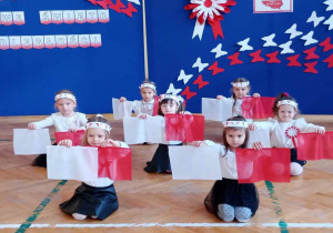 Dziewczynki z grupy Misie i Żabki prezentują tanie z flagami.