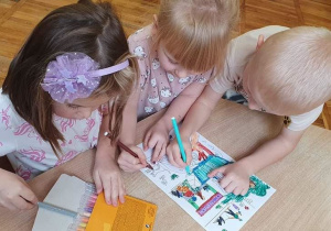 Dzieci z grupy Słoneczka kolorują malowanki.