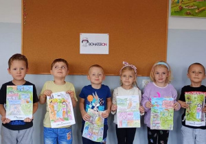 Dzieci z grupy Liski prezentują pokolorowane kolorowanki BohaterOn.
