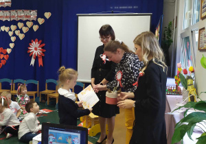 Wręczanie nagrody i dyplomu dziewczynce, która przygotowała pracę konkursową.