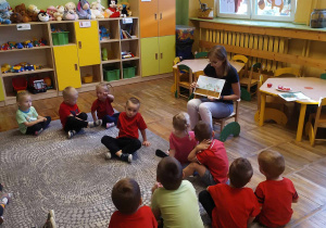 Dzieci z grupy "Krasnale" uważnie słuchają nauczyciela, który tłumaczy jak rośnie pomidor