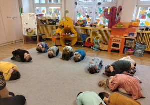 Dzieci z grupy Tropiciele ćwiczą pozycję żółwia.
