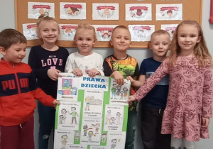 Dzieci z grupy Liski prezentują przygotowany przez siebie plakat zawierający ilustracje z prawami dziecka.
