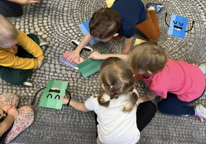 Dzieci układają na dywanie sylwety kredek pod względem kolorów