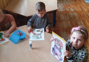 Dzieci kolorują malowanki przedstawiające misie.