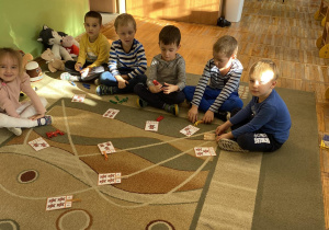 Dzieci zaznaczają na obrazkach spinaczami cyfrę odpowiadającą ilości misiów na obrazku.