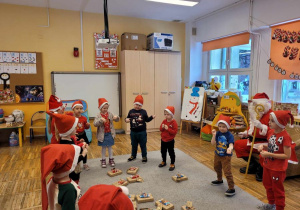 Dzieci tańczą i śpiewają Mikołajowi piosenkę.