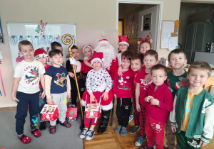 Dzieci z grupy Tropiciele na wspólnym zdjęciu z Mikołajem.