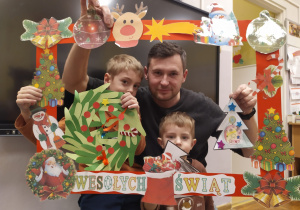 Na zdjęciu tata z dwoma synami w świątecznej foto ramce.