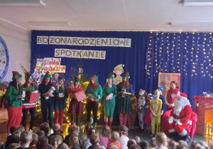 Aktorzy- nauczyciele i dzieci w czasie przedstawienia na świątecznej scenie.