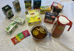 Na stoliku widzimy różne rodzaje herbat oraz przygotowaną herbatę dla dzieci do degustacji.