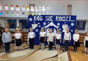 Dzieci z grupy Liski stoją odświętnie ubrane, śpiewają piosenkę.