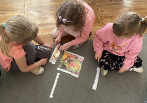 Dziewczynki układają puzzle związane z dietą wegetariańską.