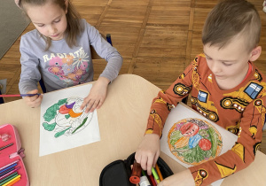 Dzieci kolorują obrazek dotyczący diety wegetariańskiej.