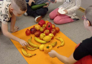 Dzieci z grupy Pszczółek tworzą „Jadalny obraz" z przyniesionych owoców i warzyw.