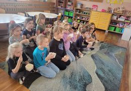 Dzieci z grupy Smerfy oglądają bajkę zajadając popcorn.