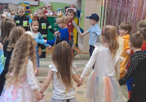 Dzieci tańczą w kółeczku, zwycięzcy konkursu balu Króla i królowej tańczą w środku.