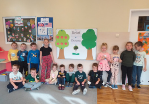 Dzieci pozują do zdjęcia podczas świętowania Dnia Drzewa.