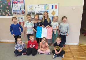 Dzieci pozują do zdjęcia z flagą Francji.