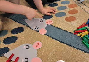 Dzieci przyczepiają odpowiednią ilość spinaczy do obrazka przedstawiającego mysz.