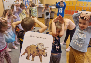 Zabawa ruchowa – dzieci pokazują rogi jak triceratops.