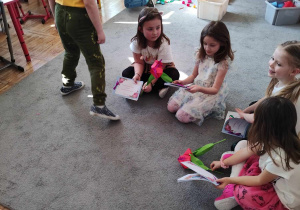Dziewczynki siedzą na dywanie z upominkami.