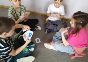 Na zdjęciu widać czwórkę dzieci grającą w matematycznego Piotrusia.